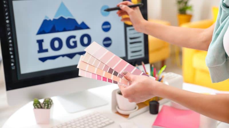 A designer picks colors for Sinoknit's logo on a computer, envisioning vibrant designs to add unique flair to customized socks.