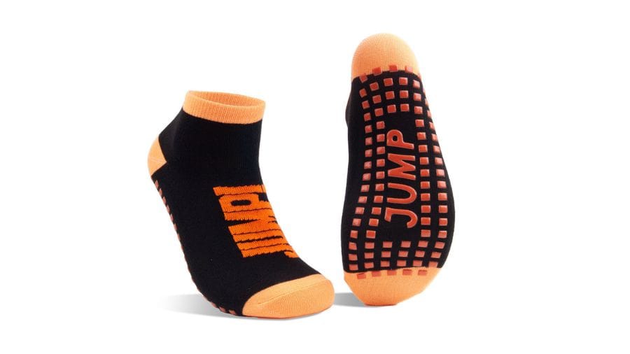 Black and orange "JUMP" socks with grip; ideal for trampoline parks. Stay comfy and safe while bouncing around!.