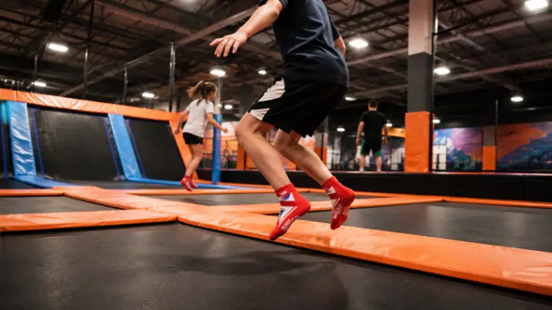 Children enjoying trampoline fun at an indoor recreational facility, emphasizing active play and safety equipment.